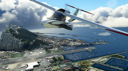 Helicopter flying over a coastal city with a mountainous landscape